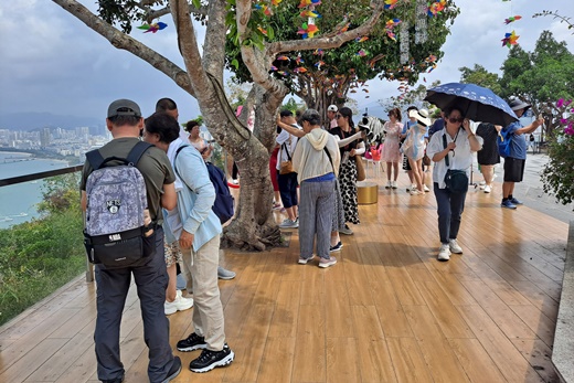 탁 트인 녹회두 정상에서 관람객들이 싼야시의 정경을 내려다보고 있다. 