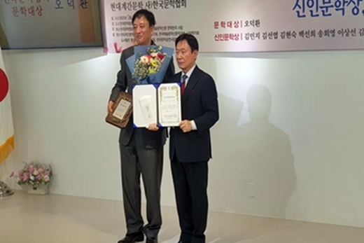 ​오덕환 문학한국 작가회장이 한국문학협회 문학대상을 받고 이사장과 함께 사진을 찍고 있다.