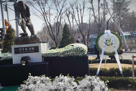 고 한주호 준위의 동상에 헌화된 꽃들이 놓여있다.